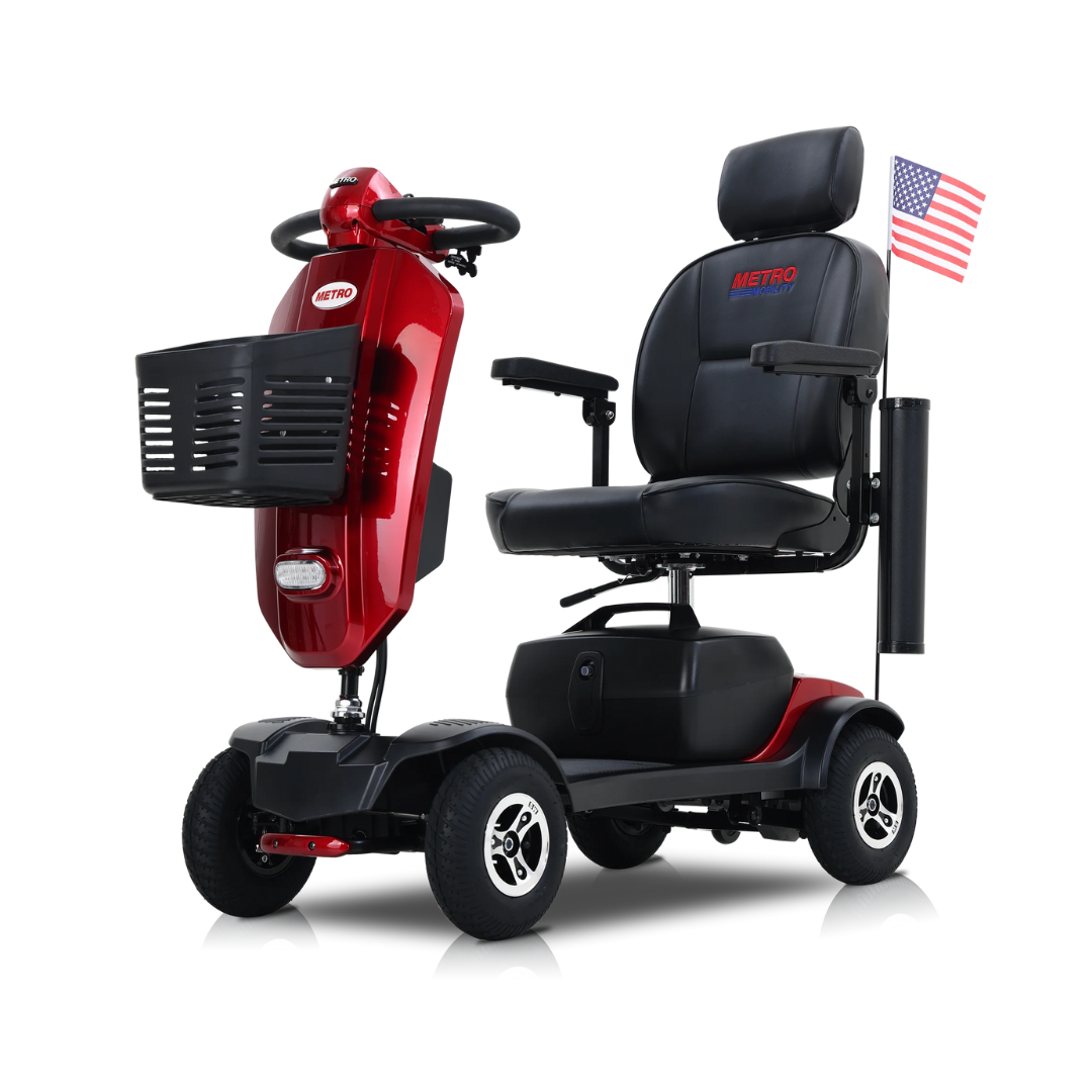 A red metro Mobility MAX Plus Scooter with four wheels, a 300W motor, black seat, front basket, and a small American flag on the backrest is shown against a white background.